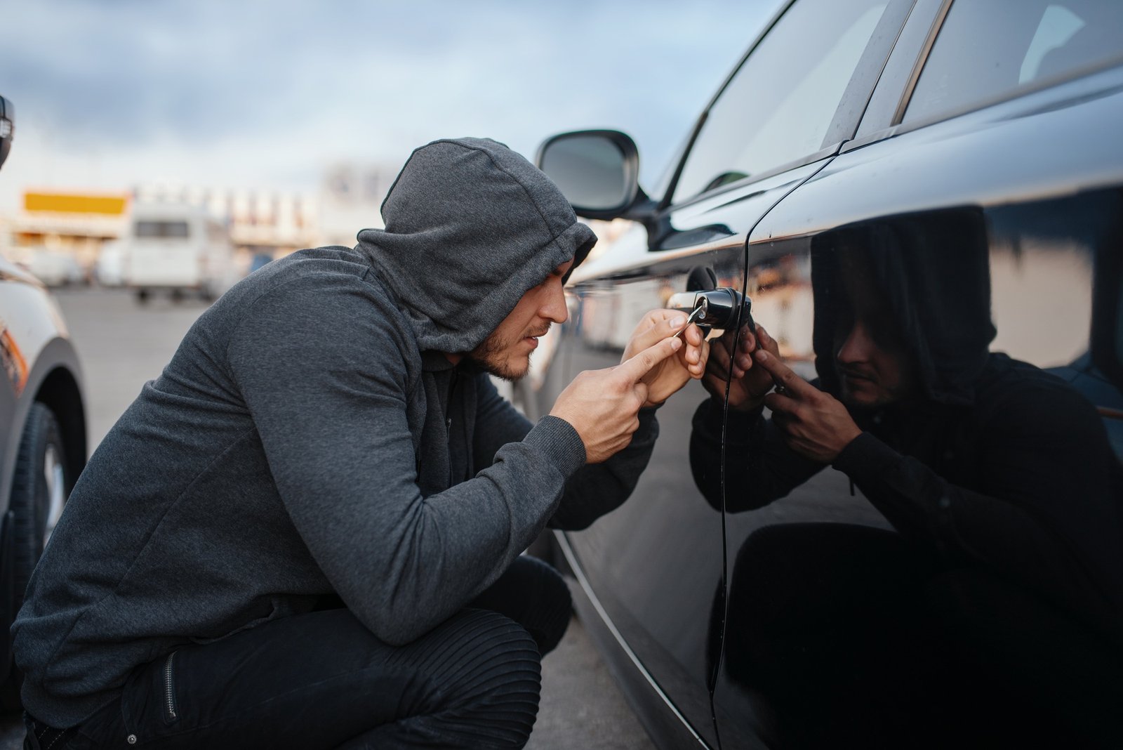 Car thief with screwdriver breaking door lock